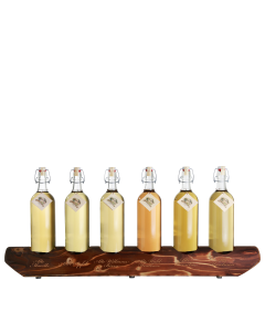 Ein rustikaler 6er-Holzständer von Prinz befüllt mit je einer 1-Liter-Flasche Alte Marille, Alter Bodensee-Apfel, Alte Williams-Christ-Birne, Alte Wald-Himbeere, Alte Kirsche und Alte Haselnuss.