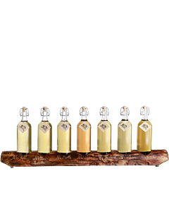 Ein rustikaler 7er-Holzständer von Prinz befüllt mit je einer 1-Liter-Flasche Alter Bodensee-Apfel, Alte Haus-Zwetschke, Alte Marille, Alte Wald-Himbeere, Alte Haselnuss, Alte Williams-Christ-Birne und Alte Kirsche.