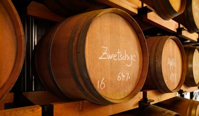 Prinz-Holzfässer im Regal: vorne Zwetschgen-Destillat mit 64 % vol.