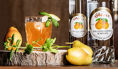 Glas met cocktail: fruitige Willibert, schnaps van Prinz op de achtergrond